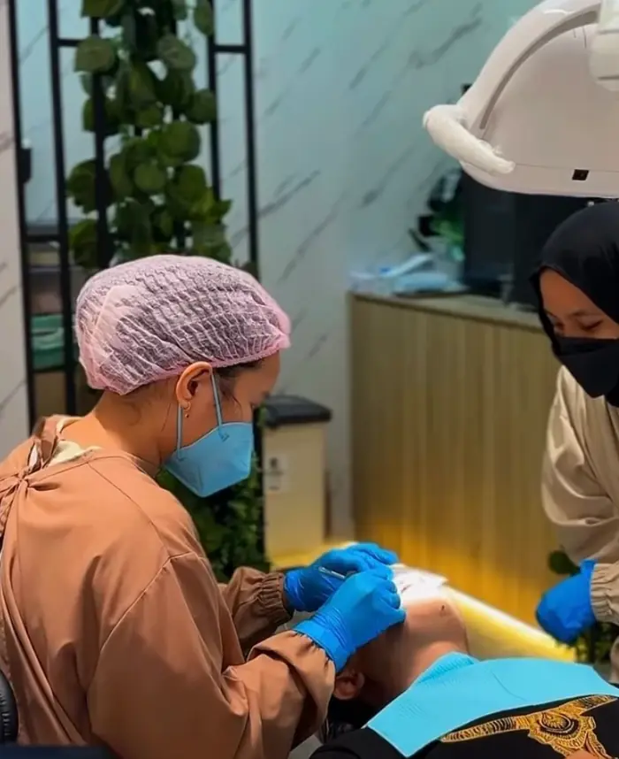 Dokter gigi Close Dental merawat pasien di ruang tindakan bernuansa hijau